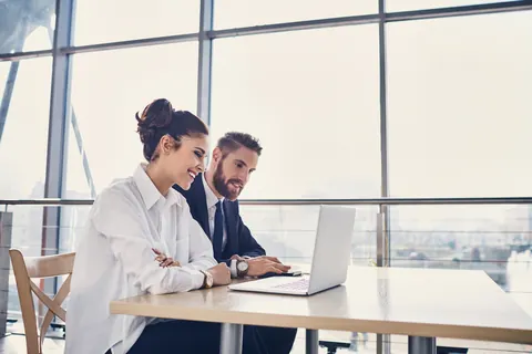 Twee professionals bekijken samen informatie op een laptop